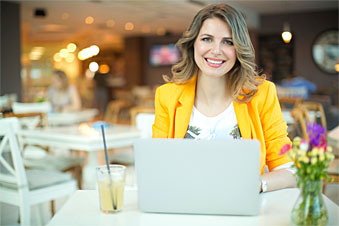Young lady smiling on laptop at a desk