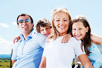 Parents with kids behind them, everyone is smiling and looking at camera