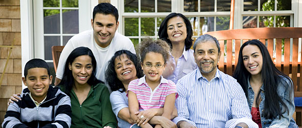 Extended family sitting on bench and smiling at camera